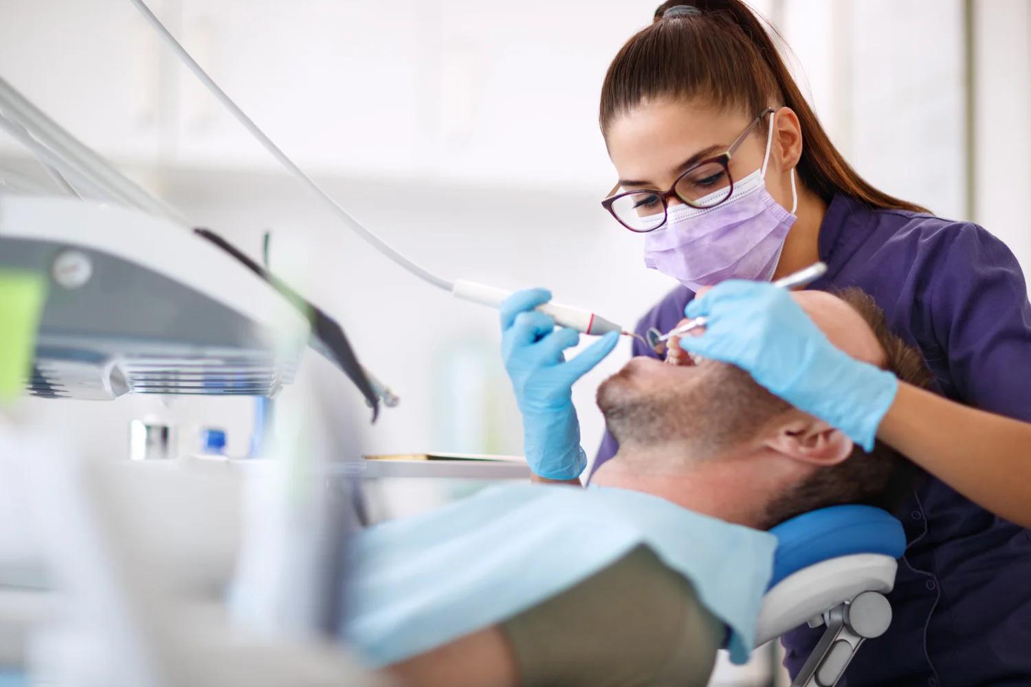 Dentist performing a professional dental cleaning to illustrate deep cleaning vs regular cleaning